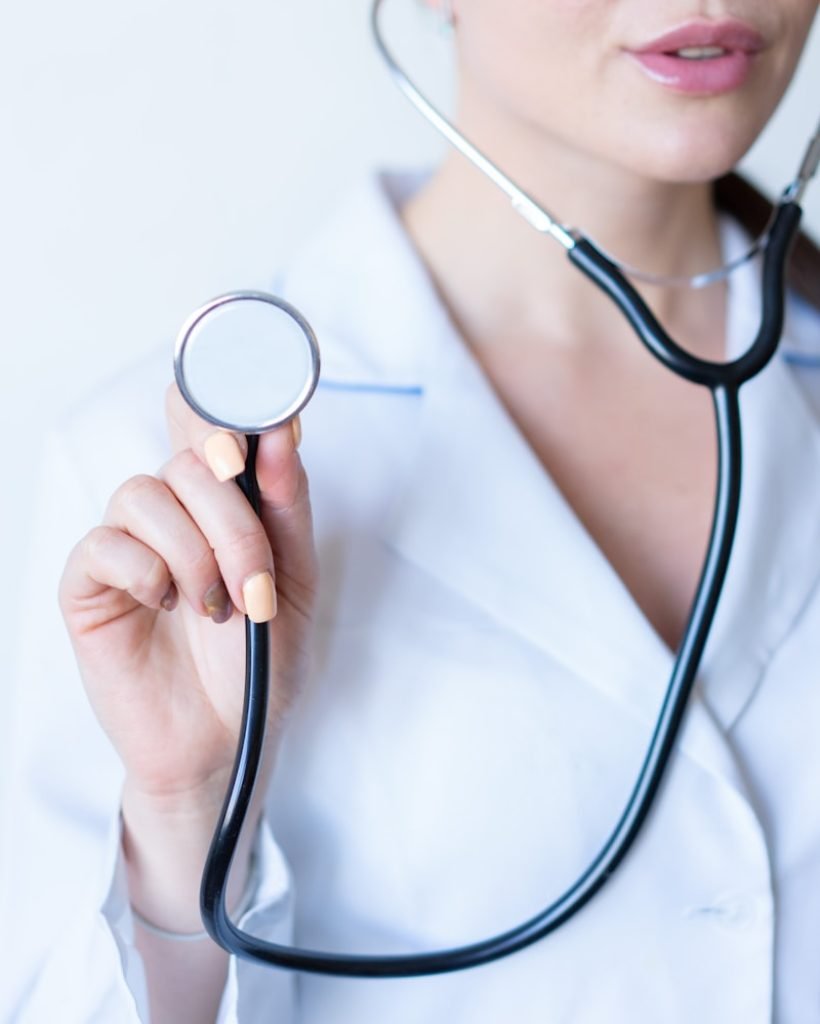 a woman in a white shirt holding a stethoscope